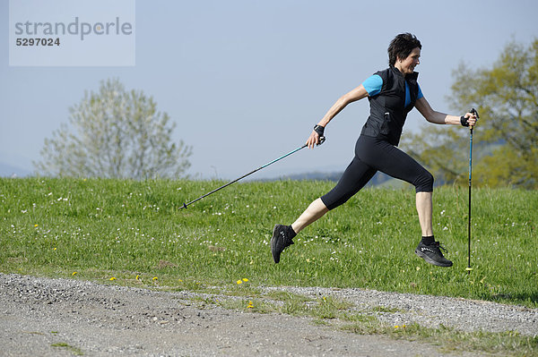 Frau beim Nordic Walking