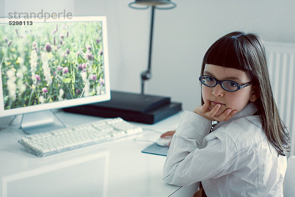 Mädchen sitzend vor dem Desktop-Computer