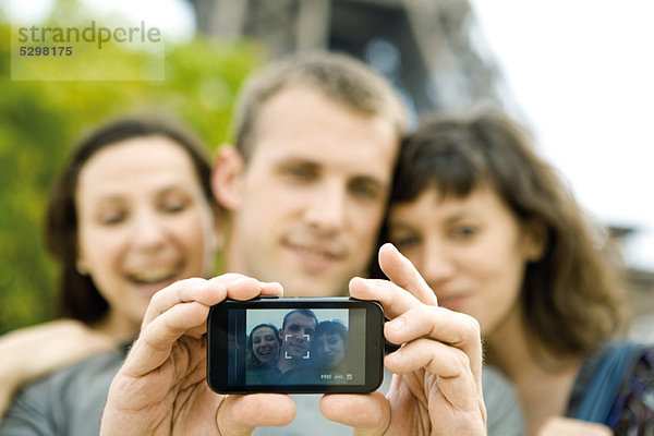 Mann fotografiert sich mit zwei Freundinnen per Handy