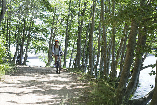 Frau fährt Fahrrad im Wald