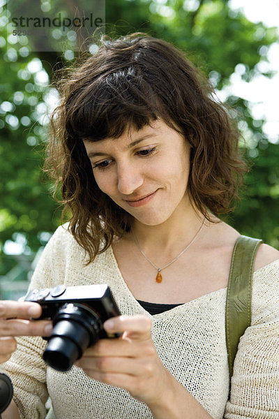 Frau betrachtet Digitalkamera