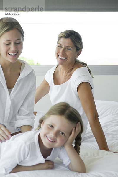 Frau entspannt auf dem Bett mit Tochter und Enkelin