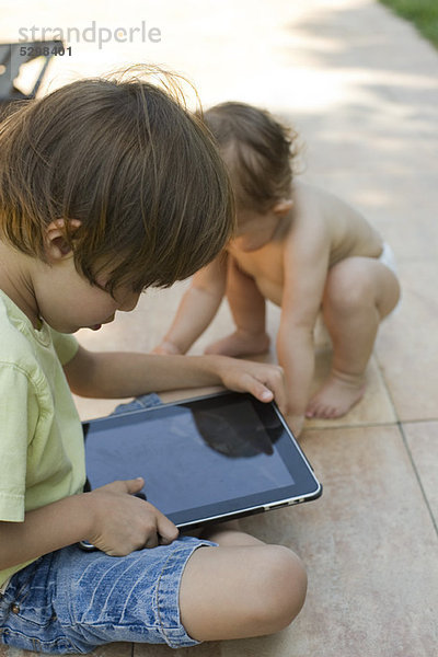 Kleiner Junge mit digitalem Tablett