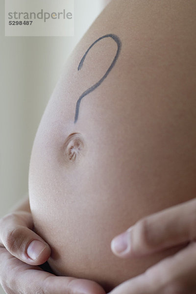 Fragezeichen am schwangeren Bauch der Frau