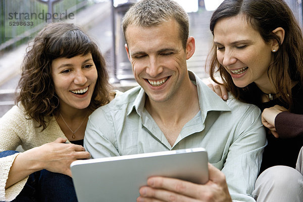 Freunde  die ein digitales Tablett im Freien benutzen