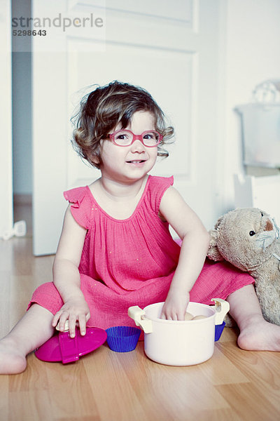 Kleines Mädchen spielt mit Spielzeugkanne