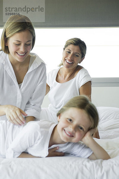 Mädchen entspannt im Bett mit ihrer Mutter und Großmutter