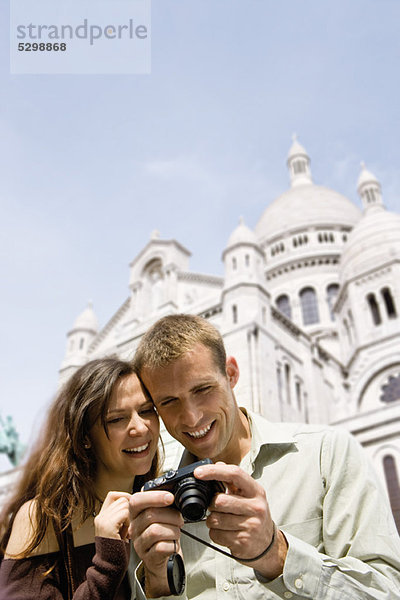 Sightseeing-Paar mit Blick auf Digitalkamera  Sacre Coeur  Montmartre  Paris  Frankreich