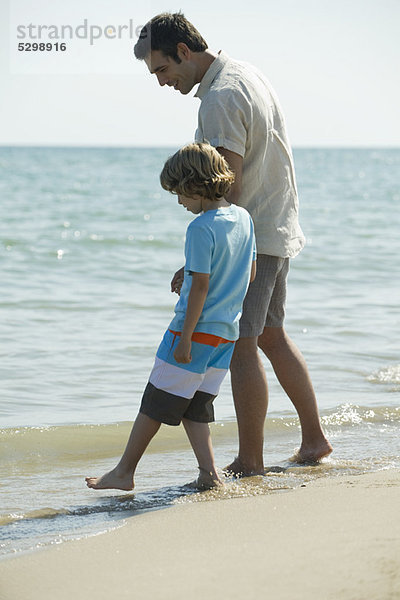Vater und Sohn beim Surfen am Strand