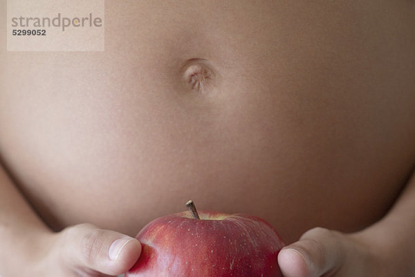 Schwangere Frau mit Apfel  abgeschnitten