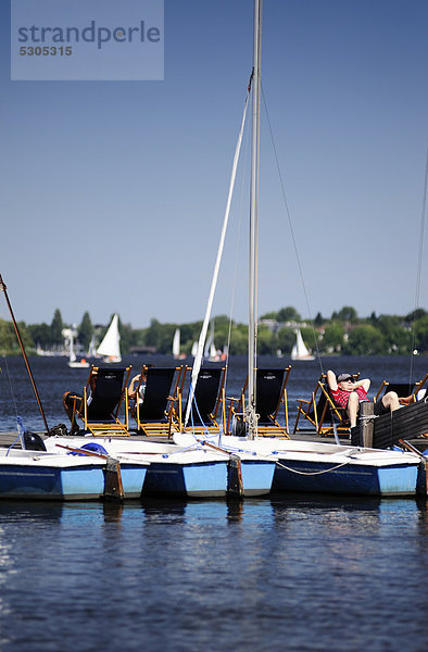 Segelboote und Bootssteg mit Liegestühlen an der Außenalster in St. Georg  Hamburg  Deutschland  Europa