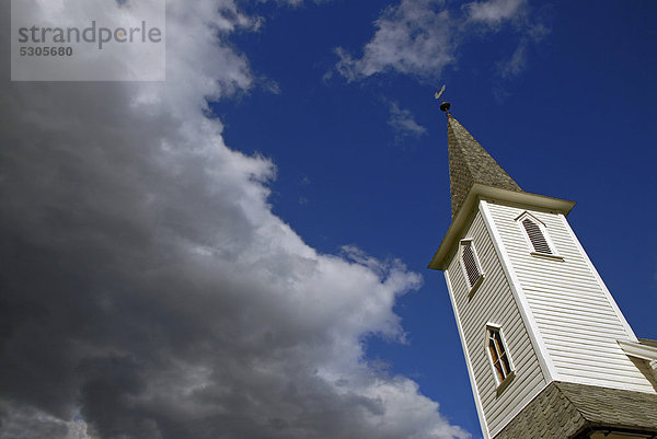 Kirchturm der Nes Kyrkje Kirche  blauer Himmel mit dunklen Wolken  Norwegen  Europa