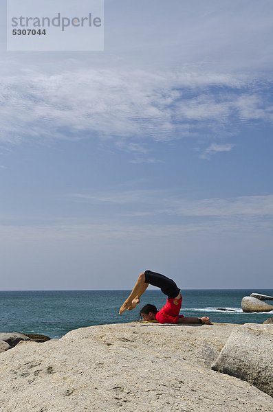 Frau in Yoga-Position Salabhasana  am Meer in Kanyakumari  Tamil Nadu  Indien  Asien