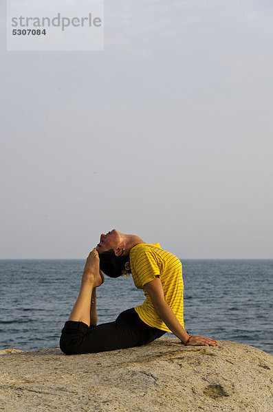 Frau in Yoga-Position Bhujangasana  am Meer in Kanyakumari  Tamil Nadu  Indien  Asien