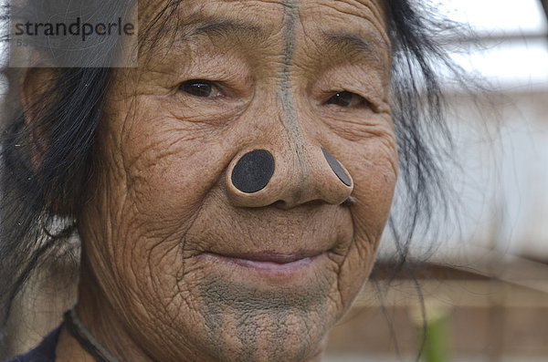 Apatani-Frau mit den traditionellen Bambus-Scheiben in den Nasenlöchern  dieser Brauch wurde eingeführt  um die Entführung der jungen Frauen aus Apatani zu verhindern  ist aber nun per Gesetz verboten  Dorf Hong in den Hügeln der Region Ziro  Arunachal Pradesh  Indien  Asien