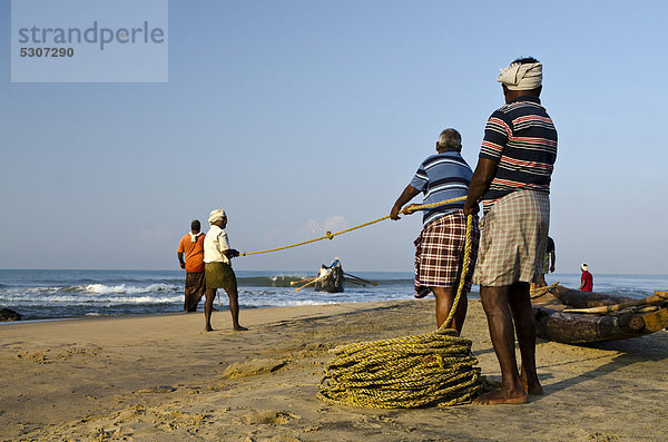 Fischer beim Fischen auf traditionelle Art und Weise in einem kleinen Dorf an der Küste bei Varkala  Kerala  Indien  Asien