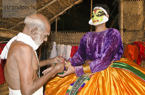 Krishna-Darsteller legt sein Kostüm an  Kathakali Tanztheater  Perattil  Kerala  Indien  Asien