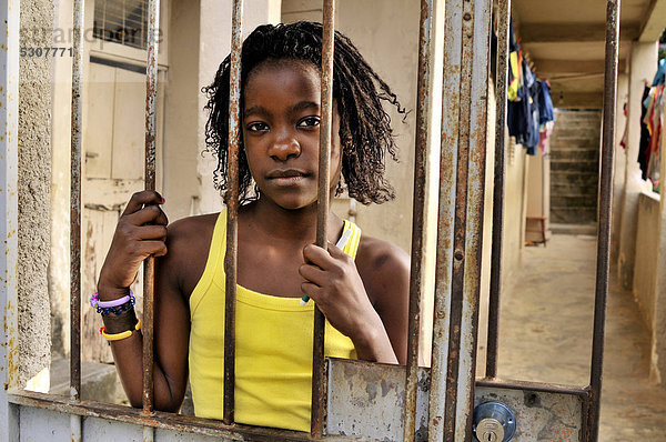 Mädchen mit ernstem Gesichtsausdruck hinter vergittertem Hauseingang  Armenviertel Favela Morro da Formiga im Stadtteil Tijuca  Rio de Janeiro  Brasilien  Südamerika