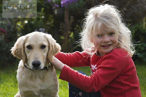 Blondes Mädchen in Garten mit Hund Golden Retriever  Bayern  Deutschland  Europa