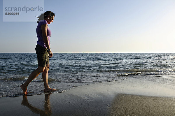Frau spaziert über den Strand  Lido di Ostia  Rom  Latium  Italien  Europa