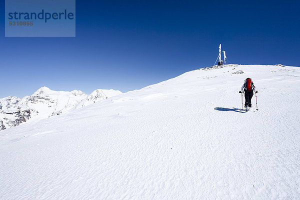 Skitourengeher beim Aufstieg zur hinteren Schöntaufspitze  Sulden im Winter  hinten der Gipfel der Schöntaufspitze mit der Wetterstation  Südtirol  Italien  Europa