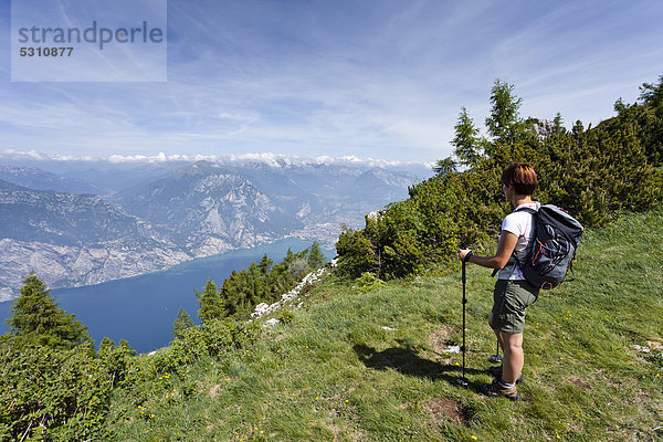 Bergsteigerin beim Aufstieg zum Monte Altissimo oberhalb von Nago  unten der Gardasee und Arco  Trentino  Italien  Europa