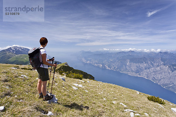 Bergsteigerin auf dem Monte Altissimo oberhalb von Nago  unten der Gardasee  hinten der Monte Baldo  Trentino  Italien  Europa