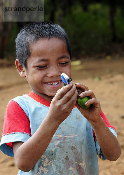 Lachender Junge mit Spielzeugauto in Laos  Südostasien  Asien