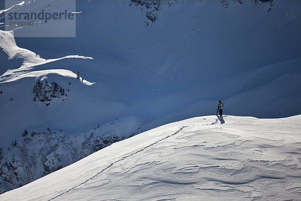 Freerider zu Fuß auf dem Weg zur Abfahrt im tiefverschneiten Gelände  Nordtirol  Österreich  Europa