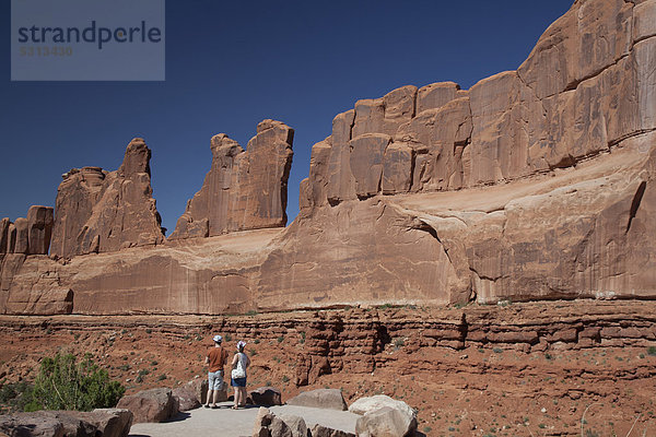 Pärchen betrachtet eine der Felswände der Park Avenue im Arches-Nationalpark  Moab  Utah  USA