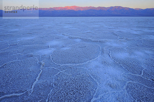 Salzpfanne  Salzkristalle  Sonnenaufgang im Badwater Basin über Panamint Range Bergkette  Death Valley Nationalpark  Mojave-Wüste  Kalifornien  Vereinigte Staaten von Amerika  USA