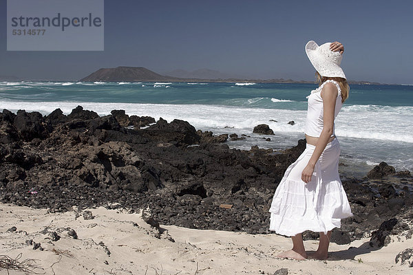 Frau am Felsstrand  Corralejo  Fuerteventura  hinten Lanzarote  Kanarische Inseln  Spanien  Europa