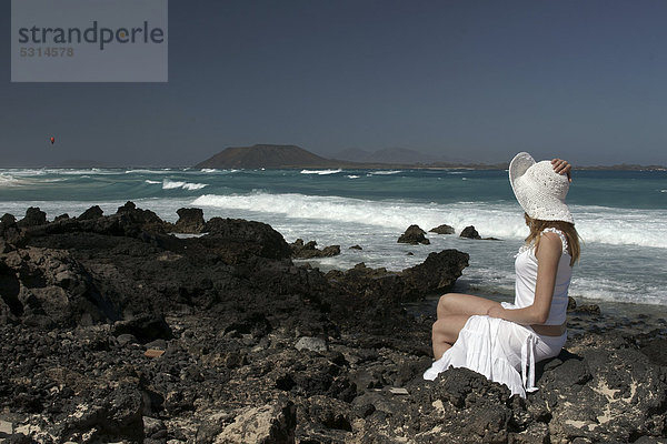 Frau am Felsstrand  Corralejo  Fuerteventura  hinten Lanzarote  Kanarische Inseln  Spanien  Europa