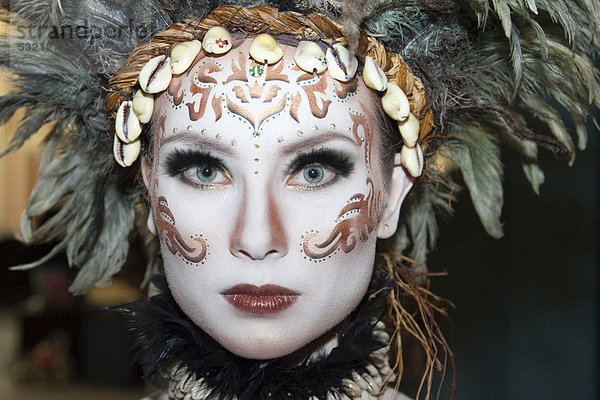 Frau trägt Stammes-Make-up mit Federn  London  England  Großbritannien  Europa