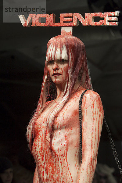 Model trägt das Zeichen Violence  Gewalt auf dem Kopf  mit Kunstblut übergossenes Model mit nacktem Oberkörper  London Fashion Week  Show von Charlie Le Mindu  London  England  Großbritannien  Europa