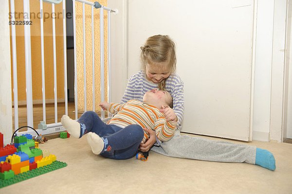Mädchen  5 Jahre  spielt mit ihrem kleinen Bruder im Kinderzimmer