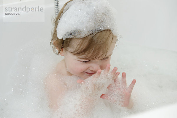 Mädchen  15 Monate  spielt mit Schaum in der Badewanne