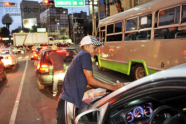 Jugendlicher  Straßenkind  putzt Autoscheiben an einer Kreuzung  um damit etwas Geld zu verdienen  Mexico City  Ciudad de Mexico  Mexiko  Mittelamerika