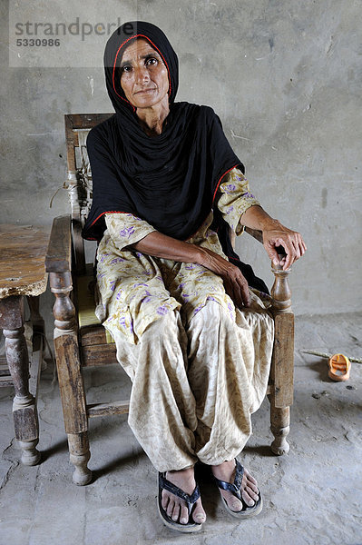 Frau sitzt in einem Stuhl  Dorf Moza Sabgogat  Punjab  Pakistan  Asien