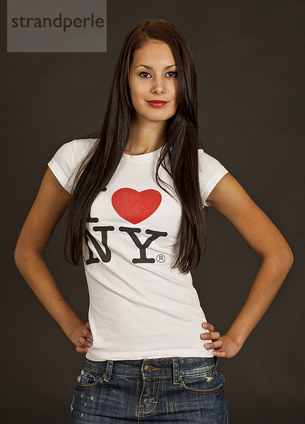 Junge Frau posiert selbstbewusst in weißem T-Shirt mit der Aufschrift I love NY