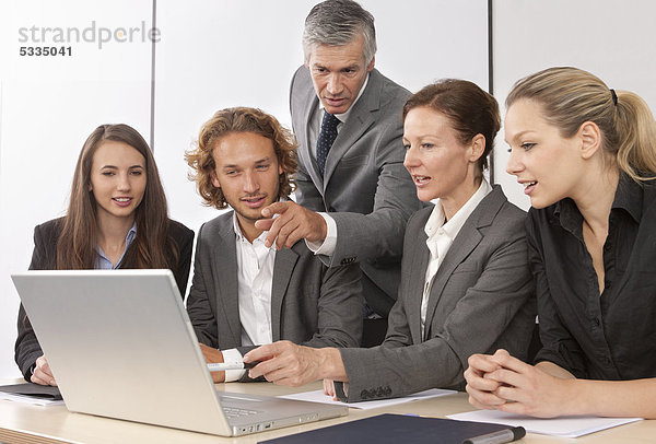 Fünf Personen schauen in Laptop