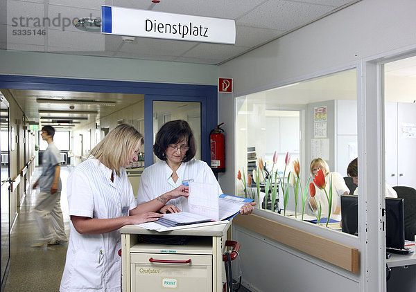 Krankenschwestern besprechen Pflegemaßnahmen  bereiten Unterlagen für die Patienten der Station vor  Krankenhaus