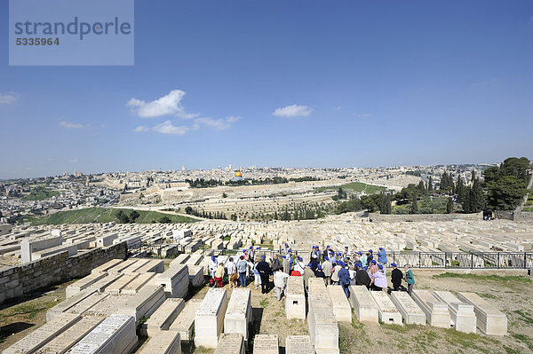 Touristengruppe bei einer Führung durch den jüdischen Friedhof am Ölberg mit Blick auf die Altstadt von Jerusalem  Israel  Naher Osten