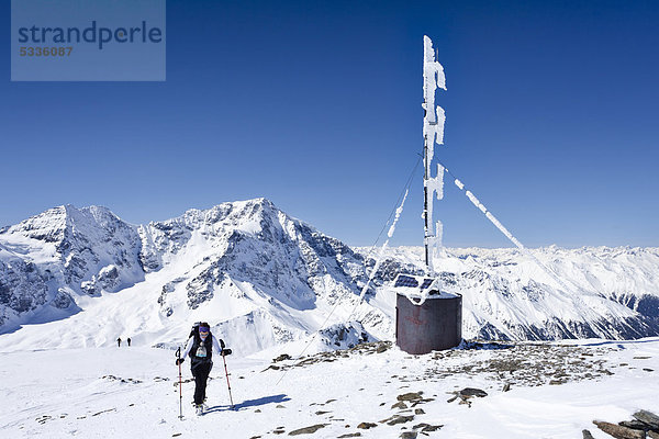Skitourengeher auf dem Gipfel der hinteren Schöntaufspitze mit der Wetterstation  hinten der Ortler und der Zebru  Sulden im Winter  Südtirol  Italien  Europa