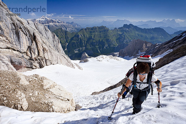 Bergsteiger beim Aufstieg zur Marmolata  Klettersteig Westgrat  hinten der Sellastock und die Heiligkreuzkofelgruppe sowie der Fedaiapass  Dolomiten  Trentino  Italien  Europa