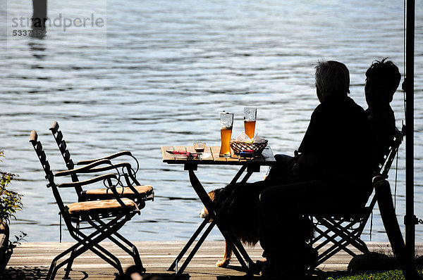 Brotzeit am See  zwei Personen am Tisch als Silhouette erkennbar  Ratzeburger See  Ratzeburg  Schleswig-Holstein  Deutschland  Europa