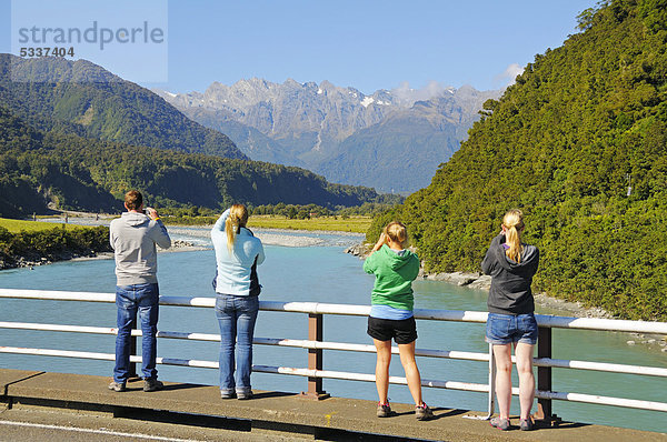 Touristen fotografieren  Fluss Whataroa  hinten die Neuseeländischen Alpen  Westküste der Südinsel von Neuseeland