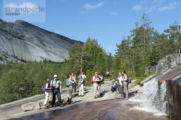 Wandern  Trekking  Wandergruppe steht am Wasserfall  Felsen aus Granit am Berg Roholtsfjell  bei VrÂdal  Vradal  Telemark  Norwegen  Skandinavien  Nordeuropa  Europa