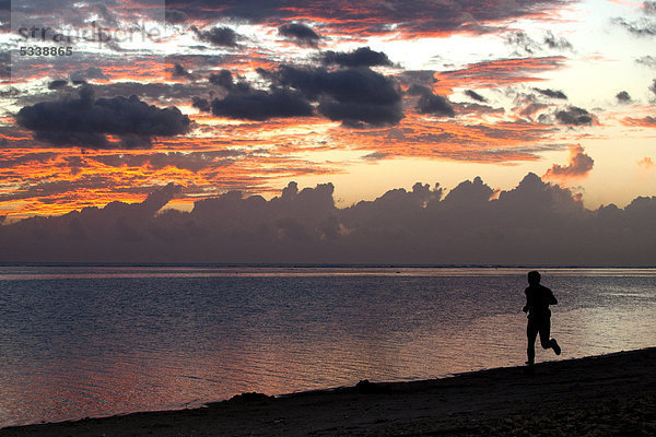 Mann beim Joggen bei Sonnenuntergang am Strand von Saline-les-Bains  Insel La Reunion  Indischer Ozean