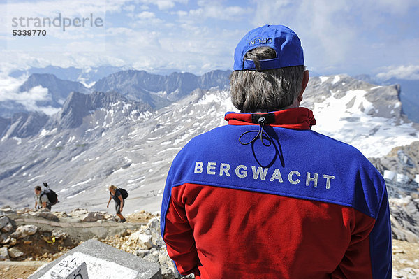 Ein Mitglied der Bergwacht beobachtet Bergsteiger auf ihrem Weg zum Gipfel  Zugspitze  Bayern  Deutschland  Europa